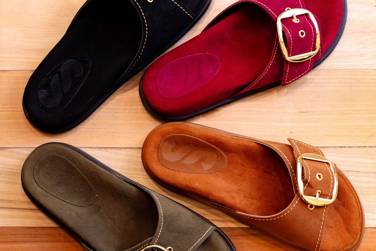 Deux paires de Birkenstock Arizona et Boston posées côte à côte sur un sol clair, étiquettes de prix visibles